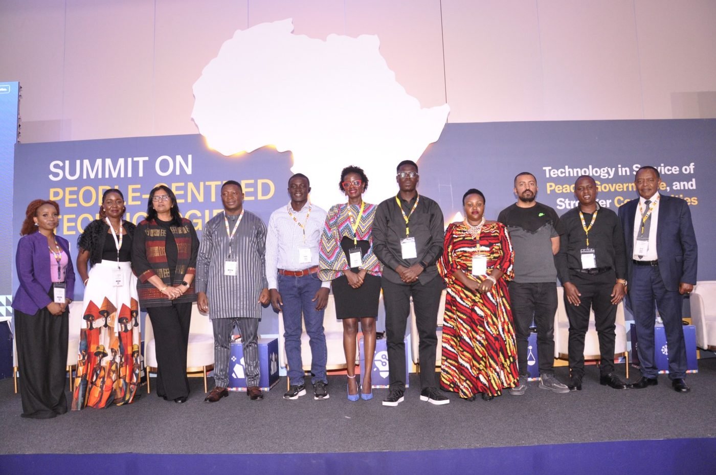 Speakers and panelists lined up on stage at the end of the summit