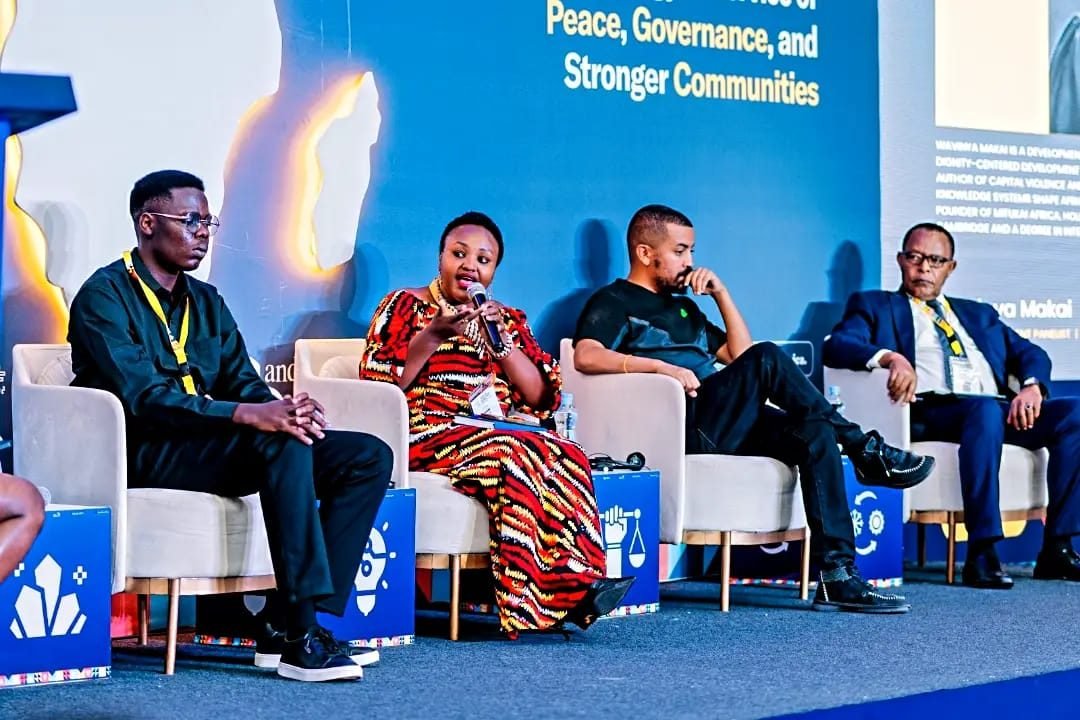 Four panelists seated on stage during a discussion on technology for peace, governance, and stronger communities